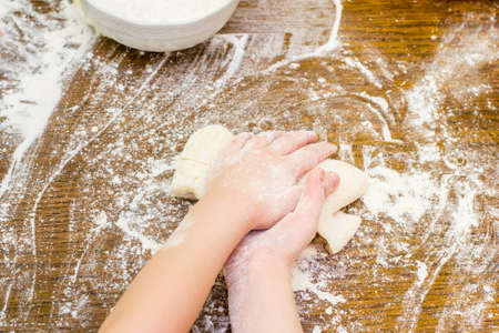 Children's hands preparing dough for cookies