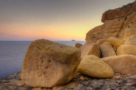 A beautiful sunset over the island of Filfla just outside Malta in the Mediterranean Sea の写真素材