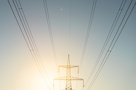 top old electrical pillar on a background of the blue sky with new moon.