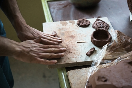 A lace maker and ceramicist create artwork. Hands top view