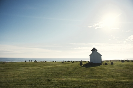 church in foreground and sea with blue sky