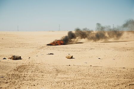 The fire and heavy smoke in the desert near the settlement during drought. Burning garbage and plasticの写真素材