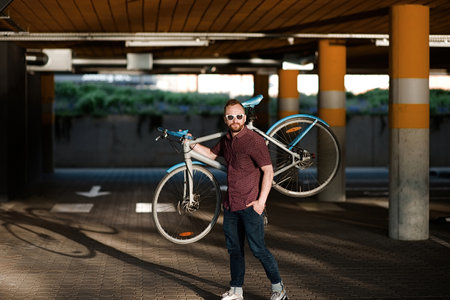 A handsome redhead male holding blue bicycleの写真素材