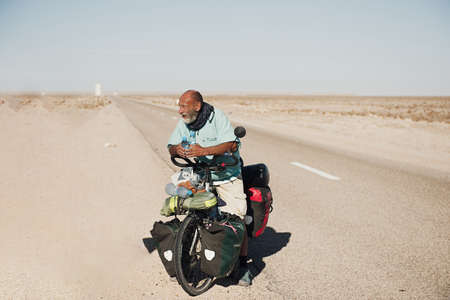 Nouadhibou, Mauritania, JANUARY 18, 2020: Man on bicycle cycling on Mauritania desertのeditorial素材