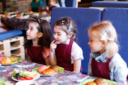 Kids in a cafe learning how to cook burgers.のeditorial素材
