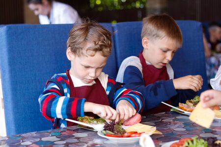 Kids in a cafe learning how to cook burgersのeditorial素材