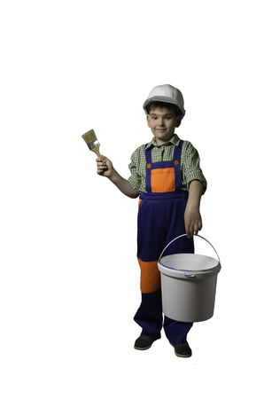 Boy, teenager with tools for repair and construction, in overalls and helmet, isolated.の写真素材
