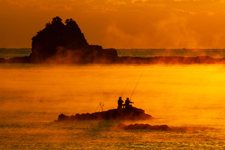 Two anglers wrapped in sea mist in Taharaの写真素材