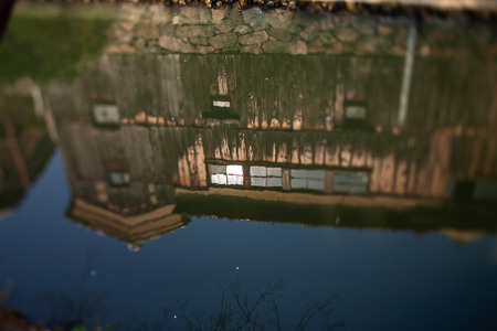 Old folk house reflected in a moat photographed in a miniature styleの写真素材