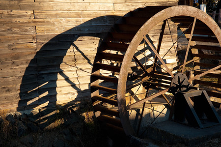 Old and rusted water wheel and shadowの写真素材