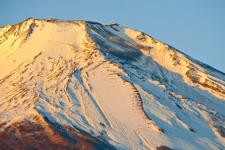 A mountain trail with a pile of snow on the morning sunの写真素材