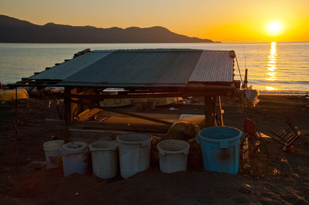 Fishery base set on the sandy beach at sunsetの写真素材