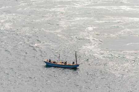 A ship sailing in fast-paced watersの写真素材