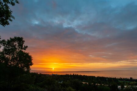 Bright red sunrise, sun and treesの写真素材