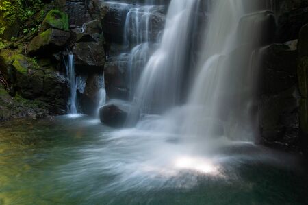 A clear water waterfall deep in the forestの写真素材