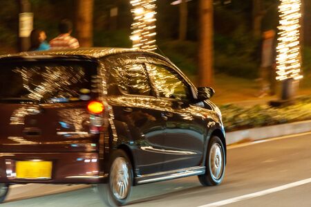 A car running on a road decorated with illuminationsの写真素材