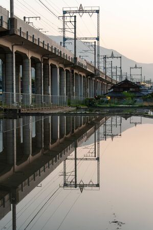 Railway tracks reflected in the dawn sky and paddy fieldsの写真素材