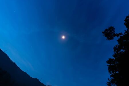 Full moon shines and cloudy skyの写真素材