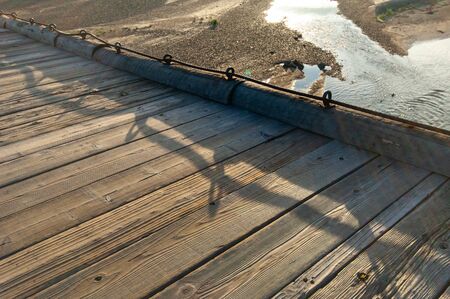 A wooden bridge in Kyoto, shadowed by the morning light.の写真素材