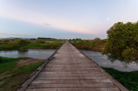A wooden bridge over a river in Kyotoの写真素材