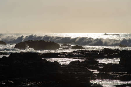 Rocks and waves and the sea at sunriseの写真素材