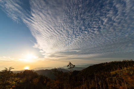 The morning sun, mountains and scaly cloudsの写真素材