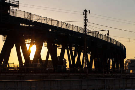 A steel bridge under construction and the sunsetの写真素材