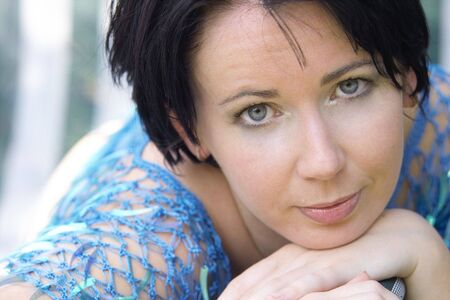 beautiful natural girl in blue restling on her handsの写真素材