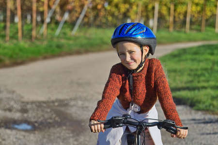 girl having fun riding her bicycle in wineyardsの写真素材