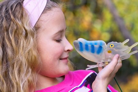 portrait of a beautiful young girl outside in the garden with butterflyの写真素材