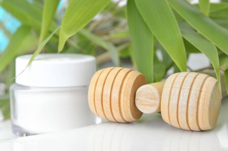 Massage block and cream container in front of bambooの写真素材