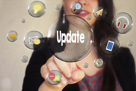 Portrait of a beautiful young woman pointing her finger to Update in transparent bubbleの写真素材