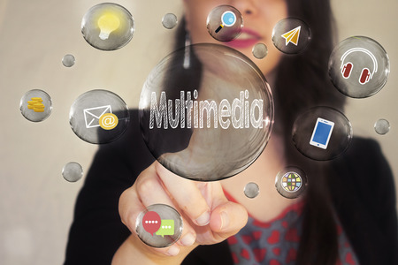 Portrait of a beautiful young woman pointing her finger to Multimedia in transparent bubbleの写真素材