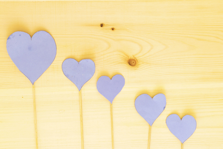 four blue heart paper with wooden stick on wood tableの写真素材
