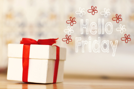 hello friday message with white gift box with red ribbon on wood backgroundの写真素材