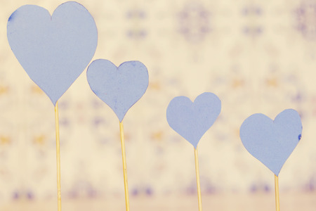 four blue heart paper with wooden stick on blue backgroundの写真素材