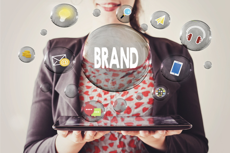 woman with beautiful smile holding a tablet and brand concept in transparent bubbleの写真素材