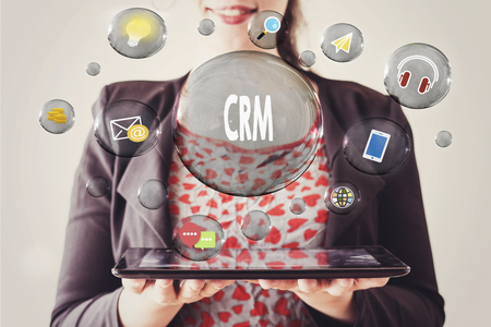 woman with beautiful smile holding a tablet and crm concept in transparent bubbleの写真素材