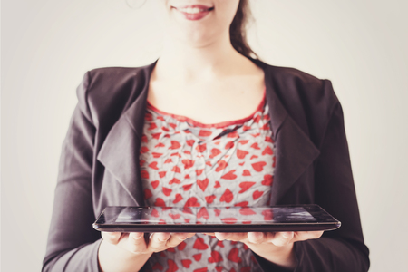 beautiful business woman with a beautiful sexy lips holding a black tabletの写真素材