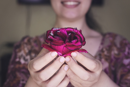 woman with beautiful smile hold a beautiful rose flowerの写真素材