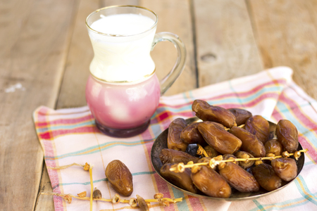 dates and milk above napkin and on wood table this is typical snack for breakfast in Ramadan or  wedding for muslim peopleの写真素材