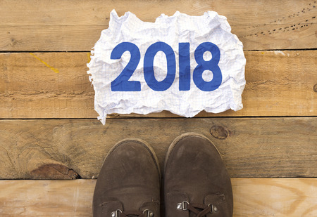 person stand up on wood and 2018 message written in crumpled and crashed paperの写真素材