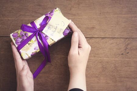 woman  holding a a gift with happy valentine's day card