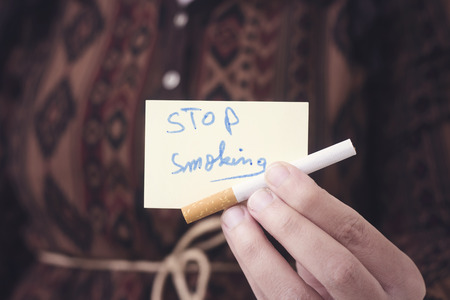 woman holding cigarette and stop smoking paperの写真素材