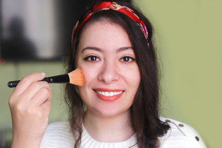 crazy beautiful arab woman holding a brush makeup and looking to cameraの写真素材