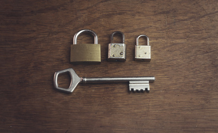 three different padlock and one big keyの写真素材