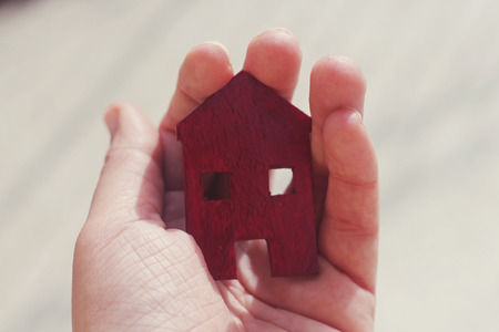 real estate agent female hand  holding a small red house, sell house business conceptの写真素材