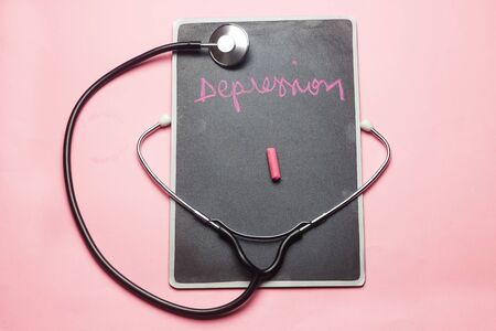 disease Depression  concept handwriting on chalkboard and stethoscope on pink backgroundの写真素材