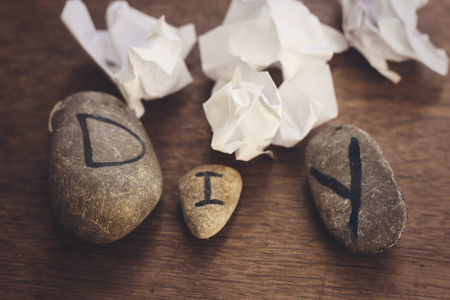 stones letters of DIY and crumpled paper  on wood backgroundの写真素材