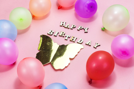 Wooden letters forming happy birthday decorated with colorful balloons , holiday conceptの写真素材